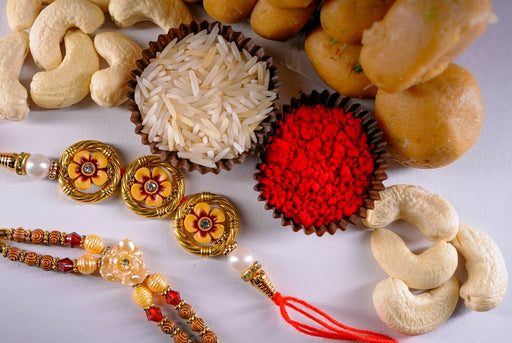 Get delicious kesar peda and roasted Cashew with beautiful beads rakhi Set.
