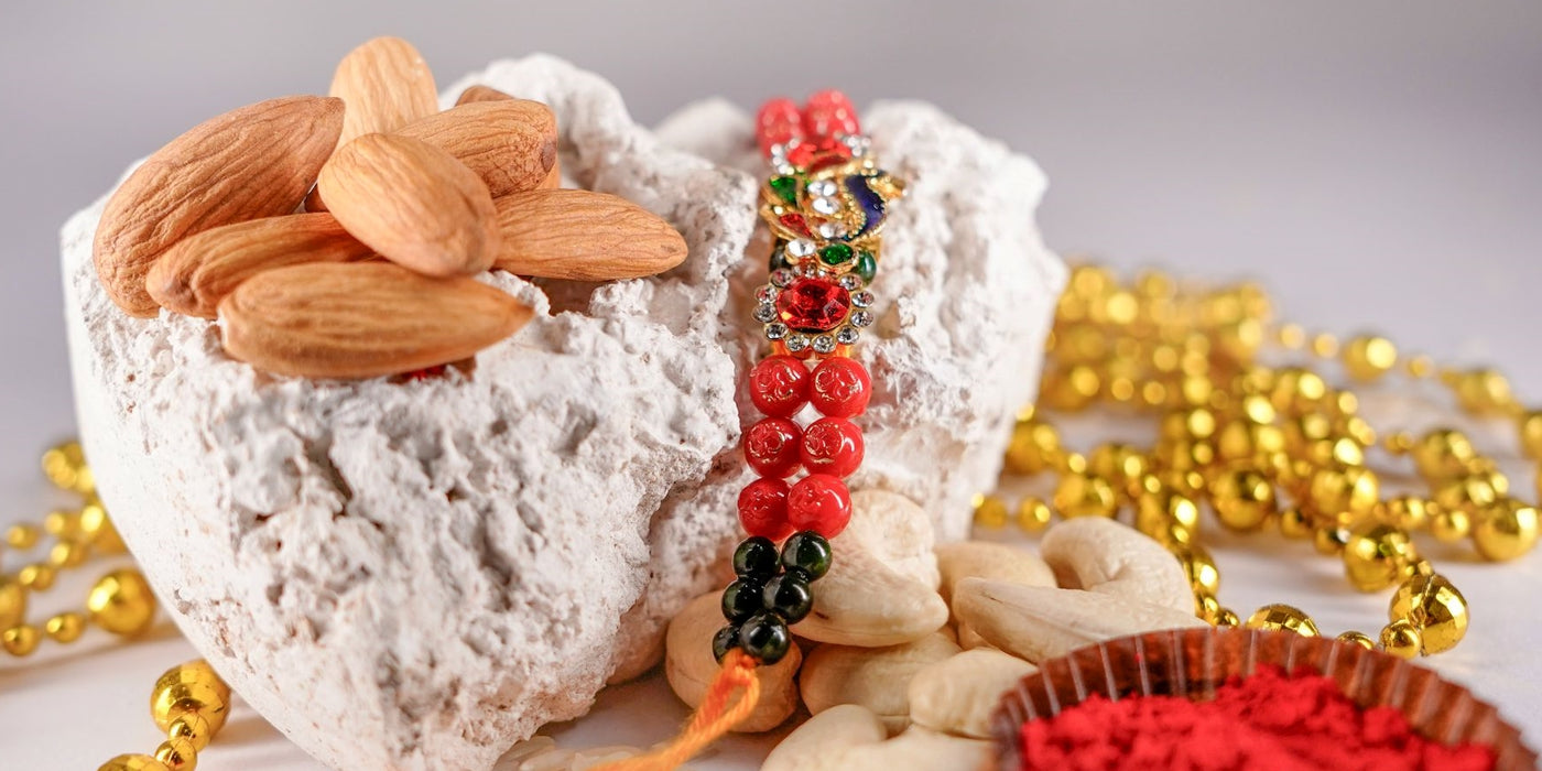 Striking Red and green  Rakhi with Salted Almonds and Cashewnuts